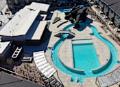 Thumbnail 24 of 29 - A swimming pool surrounded by a concrete deck and a metal railing.