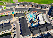 Thumbnail 29 of 29 - A large swimming pool is surrounded by apartment buildings.
