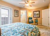 Thumbnail 23 of 34 - a bedroom with a large bed and a ceiling fan