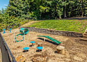 Thumbnail 23 of 23 - A playground with a green slide, a wooden log, and a green bench.