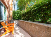 Thumbnail 20 of 30 - a small patio with orange chairs and a brick wall