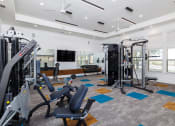 Thumbnail 24 of 35 - a gym with exercise equipment and a television
