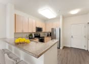 Thumbnail 7 of 21 - a kitchen with a granite counter top and a stainless steel refrigerator