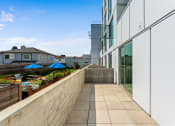 Thumbnail 15 of 54 - a balcony with a stone wall and a glass building