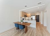 Thumbnail 2 of 54 - a dining room with a wooden table and chairs in front of a kitchen