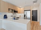 Thumbnail 1 of 54 - a kitchen with a white counter top and a stainless steel refrigerator