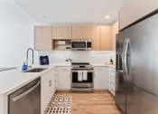 Thumbnail 6 of 54 - a modern kitchen with stainless steel appliances and white counter tops