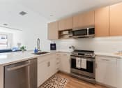 Thumbnail 7 of 54 - an apartment kitchen with stainless steel appliances and wooden cabinets