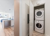 Thumbnail 54 of 54 - a front loading washer and dryer in a laundry room with a door to