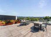Thumbnail 16 of 54 - the deck on the roof of a building with tables and chairs