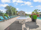 Thumbnail 17 of 36 - a pool with a ping pong table and chairs next to a pool