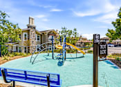 Thumbnail 14 of 57 - A playground with a blue slide and a sign that says "TOT LOT".