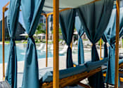 Thumbnail 57 of 59 - A poolside area with sunshades and loungers.