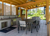 Thumbnail 53 of 59 - A patio with a table and chairs and a fireplace.