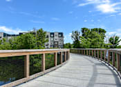 Thumbnail 25 of 35 - A bridge with a railing and a walkway in the middle of it.