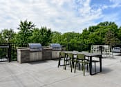 Thumbnail 35 of 35 - A patio with tables and chairs and a grill.