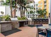 Thumbnail 15 of 34 - A patio with a grill and chairs.