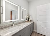 Thumbnail 11 of 50 - bathroom with back lit mirrors and granite countertops