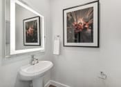 Thumbnail 6 of 50 - a bathroom with a sink and pictures on the wall