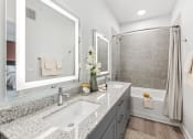 Thumbnail 22 of 50 - a white and gray bathroom with two sinks and a shower