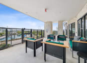 Thumbnail 39 of 50 - a balcony with tables and chairs and a view of a pool