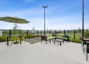 Thumbnail 45 of 50 - a patio with a table and chairs and an umbrella