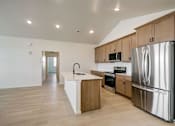 Thumbnail 6 of 23 - A kitchen with a refrigerator, sink, and oven in the model at Bloom Rental Living apartments in Fort Collins, CO