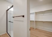 Thumbnail 5 of 23 - Model bathroom and white closet with a sliding door and shelves at Bloom Rental Living in Fort Collins, CO.