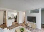 Thumbnail 6 of 25 - an open living room and kitchen with a large tv