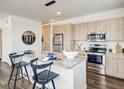 Thumbnail 11 of 28 - a kitchen with an island and a counter top with two chairs