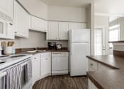 Thumbnail 3 of 14 - Kitchen with white cabinets at The Retreat at Fox Hollow Lakewood, CO apartments for rent.