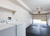 Thumbnail 18 of 28 - a laundry room with a washer and dryer and a garage door