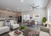 Thumbnail 11 of 31 - a living room and kitchen with a table and chairs and a ceiling fan