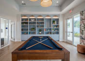 Thumbnail 8 of 59 - a pool table in a living room with a bookshelf