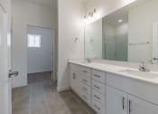 Thumbnail 47 of 59 - a white bathroom with two sinks and a large mirror
