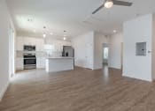 Thumbnail 44 of 59 - an empty kitchen and living room with a ceiling fan