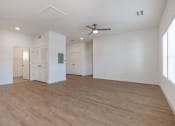 Thumbnail 45 of 59 - an empty living room with white walls and a ceiling fan