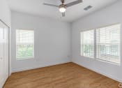 Thumbnail 55 of 59 - an empty living room with wood floors and a ceiling fan