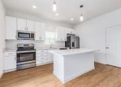 Thumbnail 52 of 59 - a large kitchen with white cabinets and stainless steel appliances