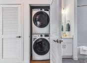 Thumbnail 22 of 59 - a white washer and dryer in a small laundry room