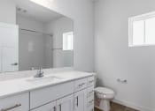 Thumbnail 49 of 59 - an empty bathroom with a toilet sink and mirror