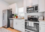 Thumbnail 12 of 59 - a kitchen with white cabinets and stainless steel appliances