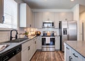 Thumbnail 18 of 24 - a kitchen with white cabinets and stainless steel appliances