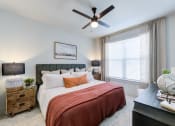 Thumbnail 14 of 24 - a bedroom with a bed and a ceiling fan
