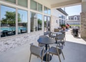 Thumbnail 24 of 24 - a patio with tables and chairs outside of a building with a pool