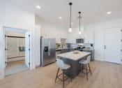 Thumbnail 11 of 59 - a large white and black kitchen with a table and chairs at Element 12 Apartments, Henderson NV