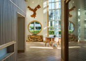 Thumbnail 4 of 32 - a dining room with a round mirror and a table and chairs