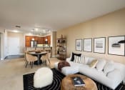 Thumbnail 23 of 32 - a living room with a white couch and a table and chairs