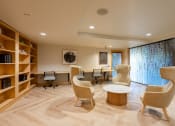 Thumbnail 14 of 32 - a living room with chairs and tables and a library