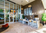 Thumbnail 2 of 32 - the lobby of a building with large glass windows and a desk with chairs